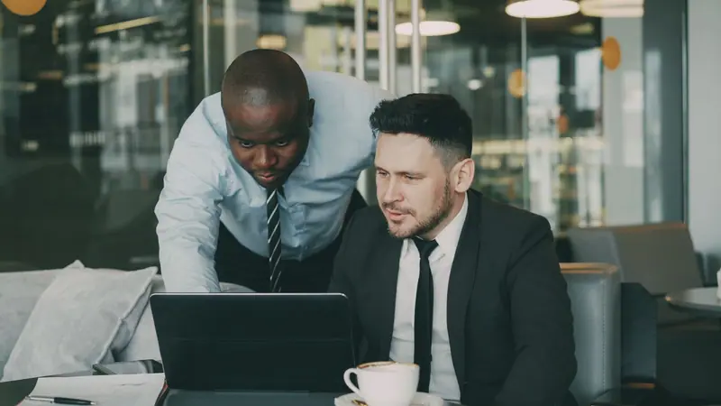 Profesionales revisando juntos una plataforma en una laptop