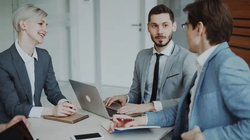 Consultores de PRAGDAL revisando indicadores con un cliente en una sala de reuniones